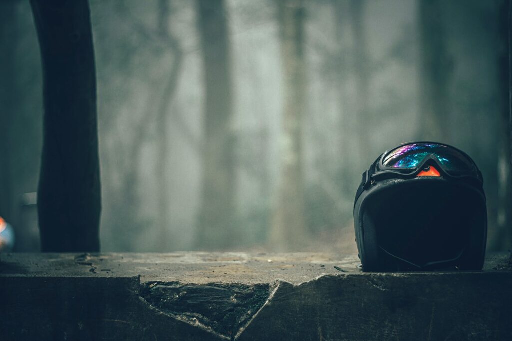 black half faced helmet on gray concrete wall